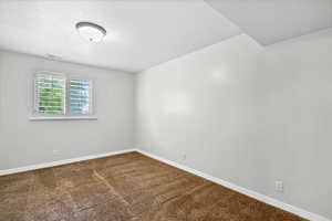 Spare room with baseboards and carpet flooring