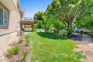 View of yard featuring central AC unit and a balcony