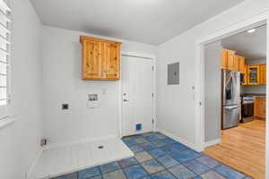 Laundry room featuring electric panel, hookup for an electric dryer, washer hookup, and baseboards