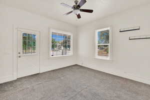 Unfurnished room with carpet flooring, a ceiling fan, and baseboards