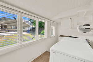 Laundry area with light tile patterned flooring and washer and dryer