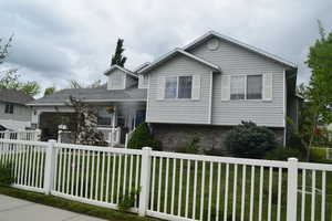 Tri-level home featuring a porch, brick siding, and a garage
