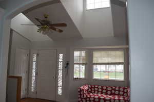 Foyer with ceiling fan, healthy amount of natural light, and a towering ceiling
