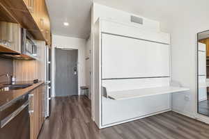 Full bath with wood finished floors, a sink, a tub to relax in, recessed lighting, and baseboards