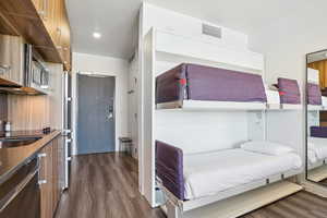Bedroom with dark wood-type flooring and a sink