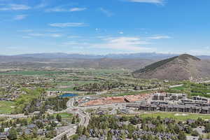 Aerial view of property and surrounding area featuring a water and mountain view