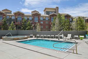 Community pool with a hot tub and a patio area