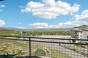 View of yard with a balcony and a mountain view