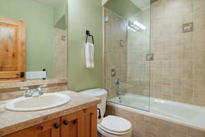 Bathroom with toilet, tiled shower / bath, and vanity