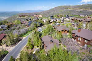 Aerial view of property and surrounding area featuring nearby suburban area and mountains