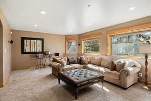 Living area with carpet flooring, recessed lighting, and baseboards