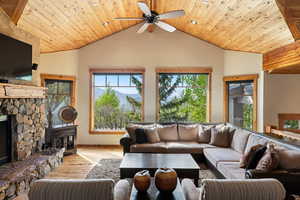 Living area with hardwood / wood-style flooring, vaulted ceiling, a ceiling fan, wooden ceiling, and baseboards