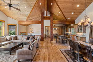 Living area with a chandelier, vaulted ceiling, light wood-type flooring, recessed lighting, and wood ceiling