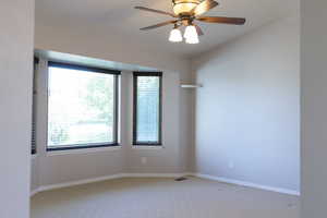 Spare room with light carpet, healthy amount of natural light, and vaulted ceiling