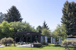 Surrounding community featuring a lawn, a pergola, and a patio
