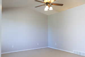 Unfurnished room with light carpet, a ceiling fan, baseboards, and lofted ceiling