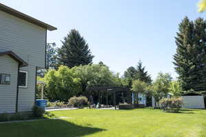 View of grassy yard featuring a pergola
