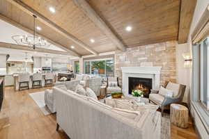 Living area with light wood-style floors, wood ceiling, a fireplace, a chandelier, and recessed lighting