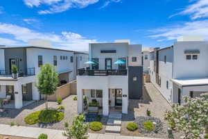 Contemporary house with a balcony, stucco siding, and a residential view