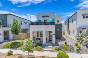Modern home featuring a balcony, stucco siding, and a porch