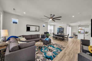 Living area with light wood finished floors, a ceiling fan, and recessed lighting