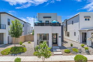 Contemporary house featuring stucco siding and a balcony