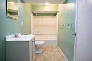 Full bath featuring toilet, vanity, bathtub / shower combination, and baseboards