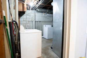 Unfinished basement featuring washing machine and clothes dryer