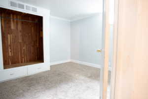 Unfurnished bedroom with carpet floors, ornamental molding, and baseboards