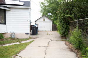 Detached garage featuring driveway and solar panels