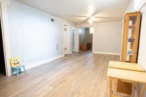 Empty room featuring ceiling fan, light wood finished floors, and baseboards