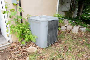 Exterior view of central air condition unit and stucco siding