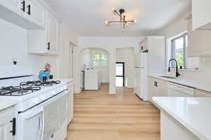 Kitchen featuring white appliances, and healthy amount of natural light