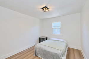 Bedroom featuring baseboards and light wood-type flooring