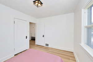 Bedroom with light wood-style flooring and baseboards