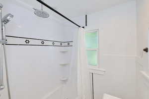 Full bath featuring shower / bath combo and crown molding