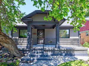 View of front of house with stucco siding and covered porch