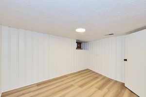 Finished basement featuring finished floors and a textured ceiling