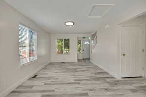 Unfurnished room with healthy amount of natural light, light wood finished floors, and baseboards