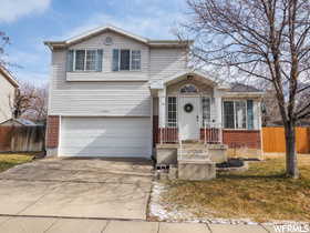 View of front of house with concrete driveway, an attached garage, and brick siding