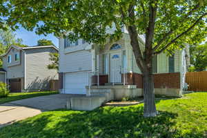 View of front of property with brick siding, concrete driveway, and an attached garage
