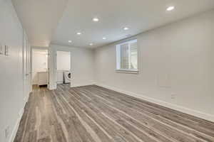 Basement with washer / dryer, baseboards, wood finished floors, and recessed lighting