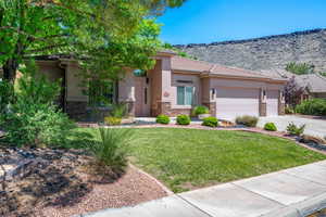 View of front of house with stone siding, an attached garage, stucco siding, and concrete driveway