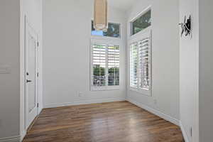 Unfurnished room with wood finished floors and baseboards