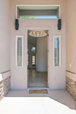 View of exterior entry with stucco siding and stone siding