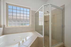 Full bathroom featuring a stall shower and a whirlpool tub