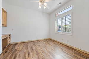 Empty room with light wood-style floors, plenty of natural light, a ceiling fan, and baseboards