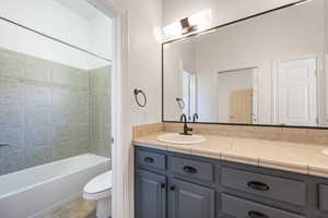Full bath featuring vanity, toilet, shower / bathtub combination, and tile patterned floors
