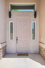 Entrance to property with stucco siding