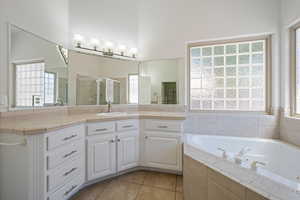 Bathroom with a stall shower, a whirlpool tub, tile patterned floors, and vanity